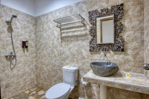 珀尼达岛Indah Guest House Nusa Penida的一间带水槽、卫生间和镜子的浴室