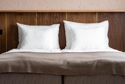 纳尔瓦Narva Hotell & Spaa的一张带白色枕头和木制床头板的床