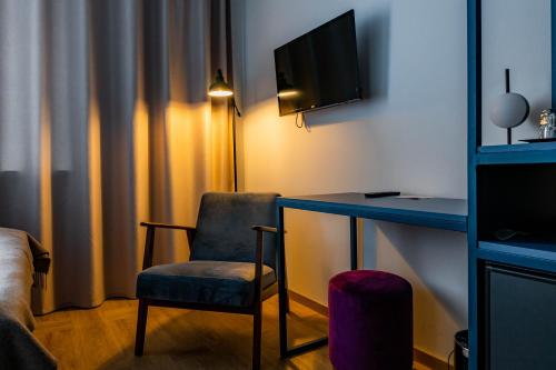 纳尔瓦Narva Hotell & Spaa的客房设有书桌、椅子和电视。