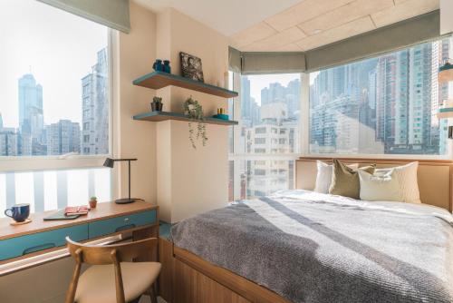 香港Weave Suites - Central West的一间卧室配有一张床、一张书桌和一个窗户。