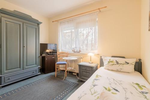 柏林Hotel Dori´s 108的一间卧室配有一张床、一张书桌和一个窗户。