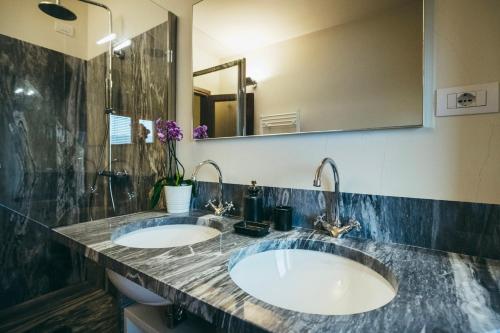 莫拉扎纳Casa Vacanza La Pozza的一间带两个盥洗盆和大镜子的浴室