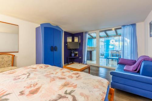班约勒Apartments Mila Banjole的一间卧室配有蓝色的床和蓝色的沙发