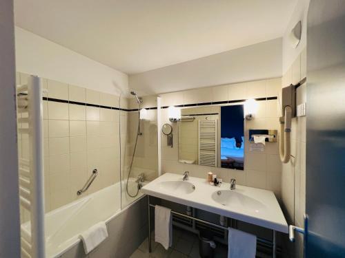 卢维耶乐普雷酒店的浴室配有水槽、淋浴和浴缸。
