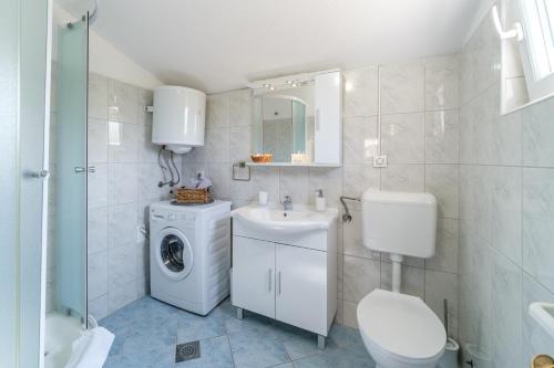 苏佩塔尔Holiday Home Gabelot的白色的浴室设有洗衣机和水槽。
