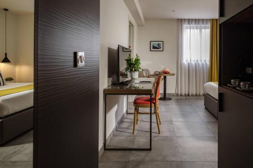 埃尔哥茨拉Urban Rooms by NEU Collective的酒店客房配有书桌和床。