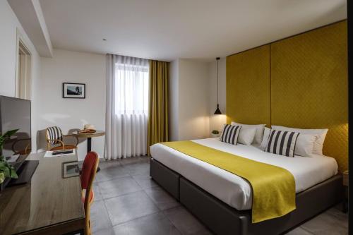 埃尔哥茨拉Urban Rooms by NEU Collective的酒店客房设有一张大床和一台电视。
