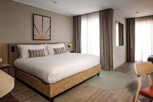 埃尔哥茨拉Strand Suites by NEU Collective的卧室配有一张白色大床