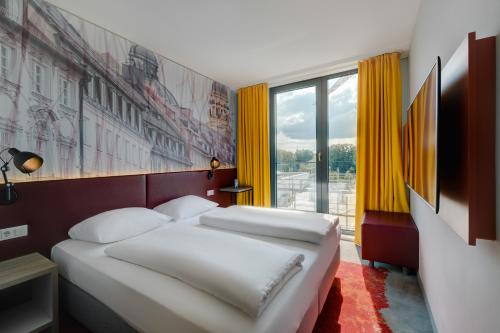 慕尼黑Campanile Muenchen Sendling的一间卧室设有两张床和大窗户