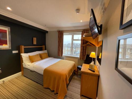泰晤士河畔里士满Shandon Hotel的酒店客房,配有床和电视