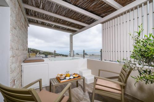 费拉圣托里尼之家别墅的阳台配有桌椅,享有海景。