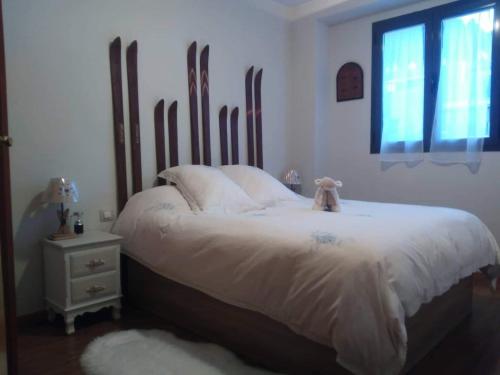 坎丹奇奥Apartamento Riglos Candanchu的一间卧室配有一张带白色床单的床和一扇窗户。