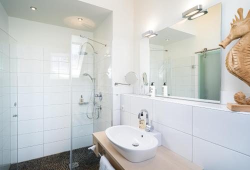 居特斯洛弗鲁贝特酒店的白色的浴室设有水槽和淋浴。