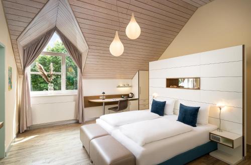 居特斯洛弗鲁贝特酒店的卧室配有一张白色的大床和一张桌子