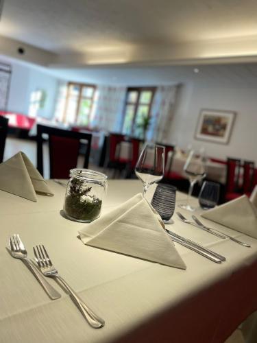 阿尔腾斯塔特Hotel & Restaurant Fischer的一张桌子上放着白色的桌布和银器