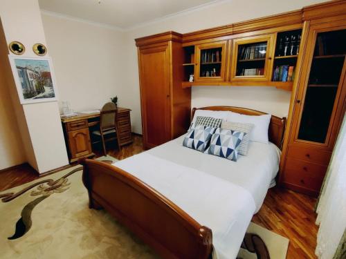 基希讷乌Kiki's Villa的一间卧室配有一张带木柜的床和一张书桌。