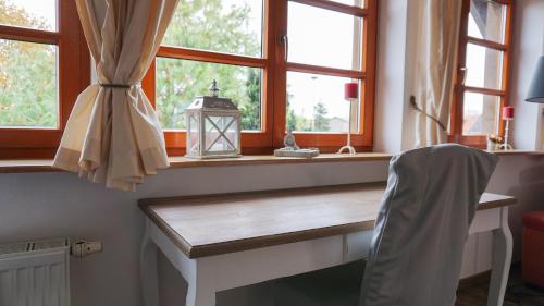 WassersuppeLandhaus Charlotte - Storchennest的窗户和灯的客房内的一张书桌