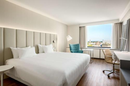 乌得勒支乌得勒支NH酒店的酒店客房设有一张白色大床和一个窗户。