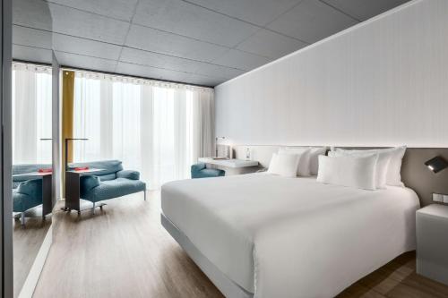 鹿特丹恩豪鹿特丹酒店的卧室配有一张白色大床和一张书桌
