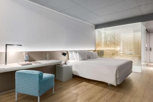 鹿特丹恩豪鹿特丹酒店的卧室配有白色的床和蓝色椅子
