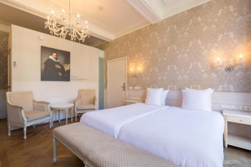 马斯特里赫特Amrâth Hotel Bigarré的卧室配有一张白色大床和吊灯。