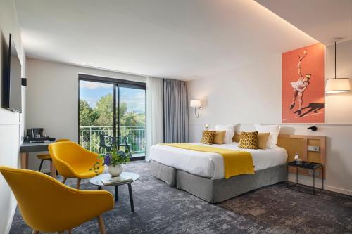 比奥Mouratoglou Hotel & Resort的酒店客房,配有床和黄色椅子