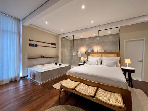 伊利亚贝拉巴拉杜萍波尔图酒店的一间卧室设有一张大床和一个浴缸