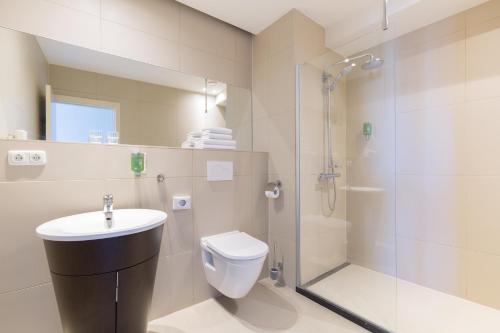 马斯特里赫特Amrâth Hotel Bigarré的浴室配有卫生间水槽和淋浴。