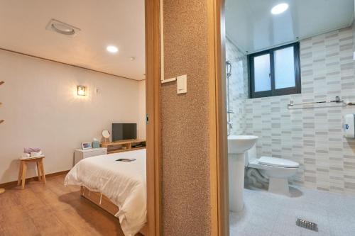 首尔K'STAY Sinchon的一间卧室配有一张床,浴室设有卫生间