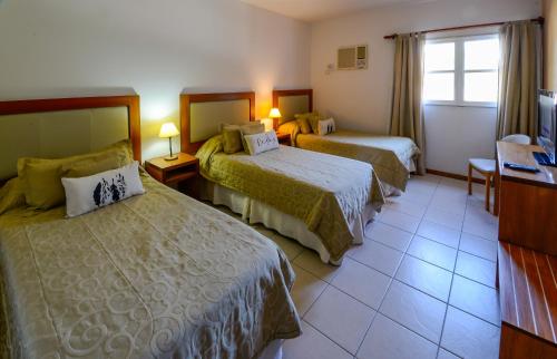 Libertador General San MartínHotel La Huertita的酒店客房设有两张床和窗户。