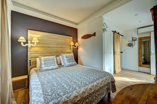 热姆诺普罗旺斯酒店的一间卧室设有一张大床和一个木制床头板