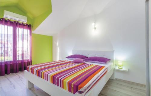 卡什泰拉Beautiful Apartment In Kastel Stafilic With 5 Bedrooms, Wifi And Outdoor Swimming Pool的一间卧室配有一张带彩色条纹毯子的床