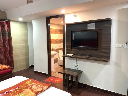 阿姆利则Hotel Sukhman Residency的客厅配有电视、床和沙发