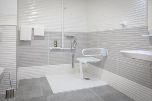 洛里昂Logis REX HOTEL Lorient的带淋浴和盥洗盆的白色浴室