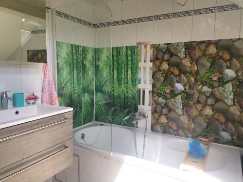 马尔梅迪Mevazara guesthouse的浴室配有淋浴、浴缸和壁画