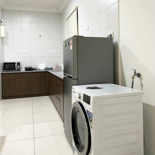 梳邦再也Damen Suite Sunway Subang by DW的厨房配有洗衣机和冰箱。