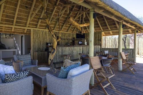 奥马鲁鲁TimBila Camp Namibia的甲板上配有桌椅的凉亭