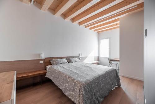 帕多瓦Palazzo '900 Design Flats - Il Pittore的一间卧室配有一张床和一张木桌