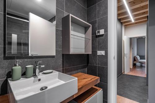 帕多瓦Palazzo '900 Design Flats - Il Pittore的浴室设有白色水槽和镜子