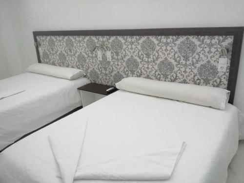 马德里HELLO HOME FERIA的墙上的房间里设有两张白色的床