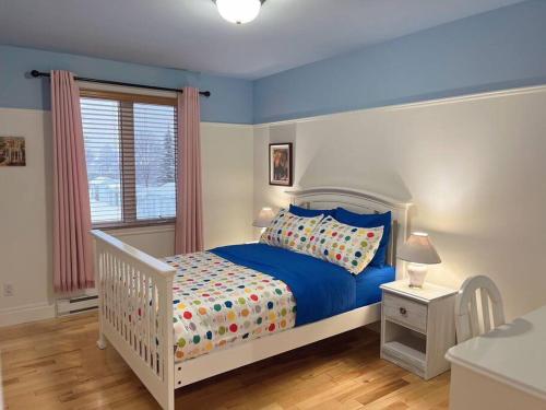 魁北克市Sweetwater House的卧室配有蓝色和白色的床和窗户。