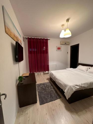 奥托佩尼Apartament Otopeni的一间卧室配有床和红色窗帘