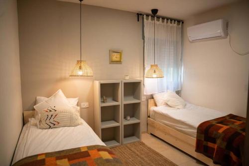 卡梅尔Brand New Zippi`s- karmiel的一间小卧室,配有两张床和两盏灯