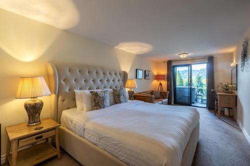 鲍内斯温德米尔Lakes Hotel & Spa的一间卧室配有一张大床和一张带台灯的桌子