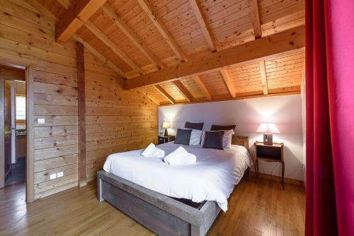 圣若里奥ST JORIOZ- Cosy Chalet vue lac et montagnes - LLA Selections by Location Lac Annecy的小木屋内一间卧室,配有一张大床