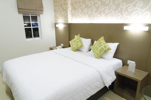 万隆约克特尔酒店的卧室配有一张带两个枕头的大白色床