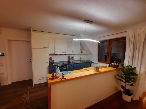 WaldseeApartments 'Niko'的厨房配有白色橱柜和蓝色台面