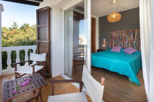 伊斯费古耶拉尔海滩Casa en Ibiza con vistas increíbles en Es Figueral的一间带绿色床的卧室和一个阳台