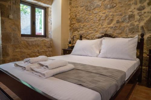 基萨莫斯IOANNIS STONEHOUSE, Quiet, Privacy & Sea View.的一间卧室配有带毛巾的床