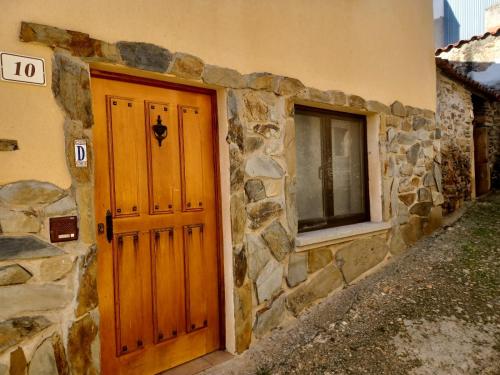 绍塞列Casa rural Las Peñas的石头建筑,设有木门和窗户